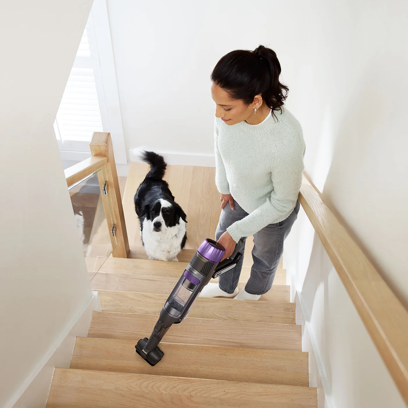 Shark-IP3251UKT-InUse-Stairs-Handvac-PetMultiTool-Woman